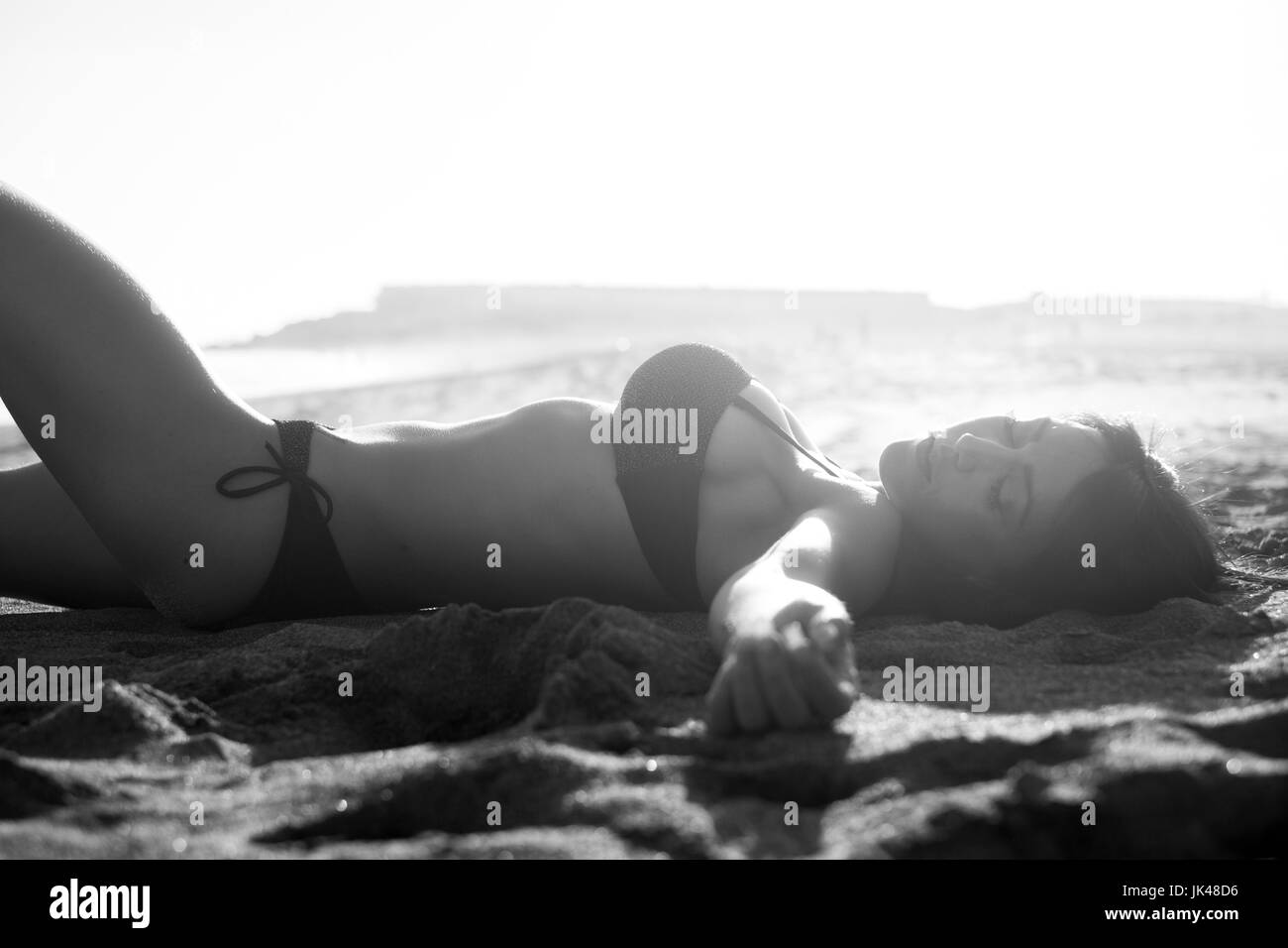 Kaukasische Frau Sonnenbaden am Strand Stockfoto