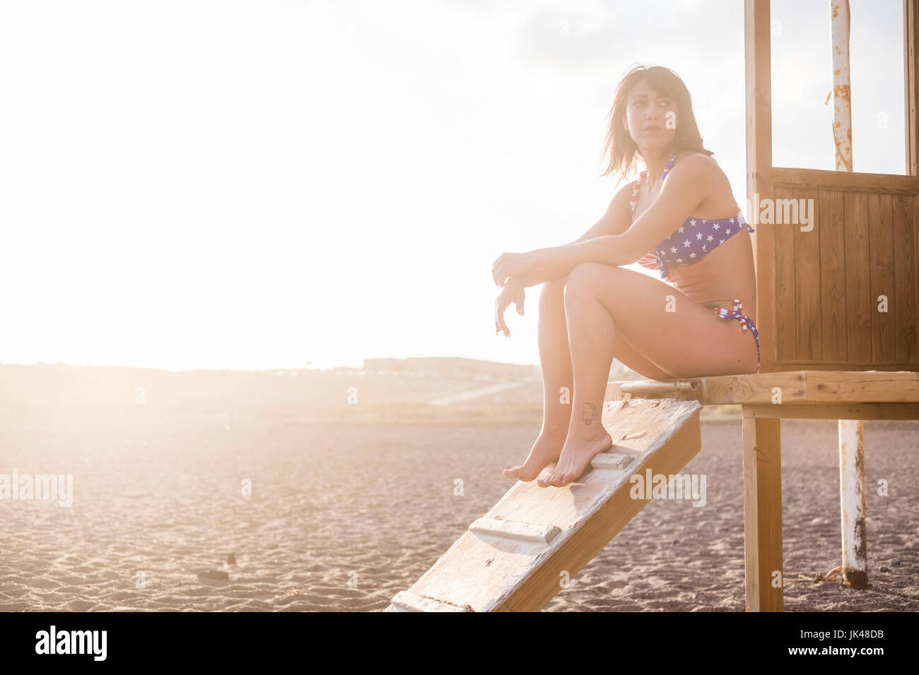 Kaukasische Frau sitzen auf Cabana am Strand Stockfoto