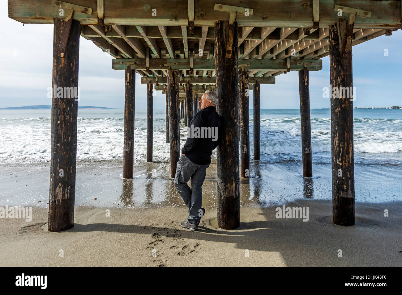 Kaukasischen Mann stützte sich auf Drängen der Holzsteg am Strand Stockfoto