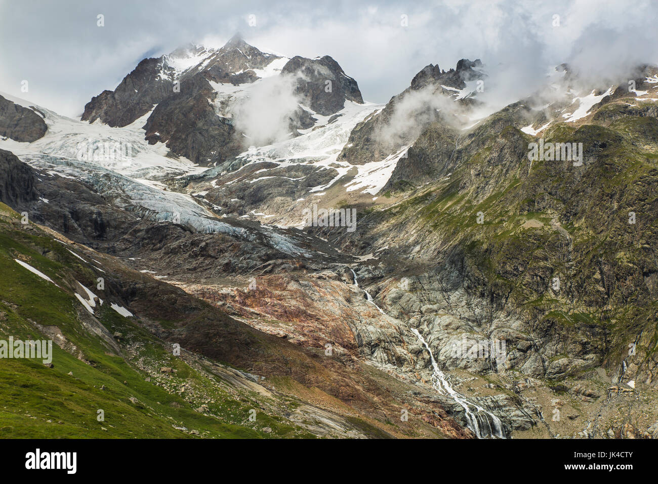 Bewölkt Eis bedeckte Berge der Alpen in der Nähe der italienischen Grenze entlang der Tour du Mont Blanc Stockfoto