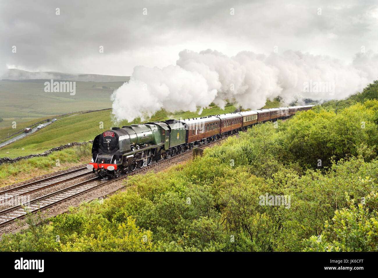 Ribblehead, UK. 22. Juli 2017. Unter Regenwolken schleppt die Herzogin von Sutherland Dampflokomotive der Cumbrian Mountain Express gebunden für Carlisle an der malerischen Settle-Carlisle Bahnstrecke in den Yorkshire Dales National Park. Abgebildet im Salt Lake Cottages in der Nähe von Ribblehead, in der Nähe von Ingleton, North Yorkshire, UK Credit: John Bentley/Alamy Live News Stockfoto