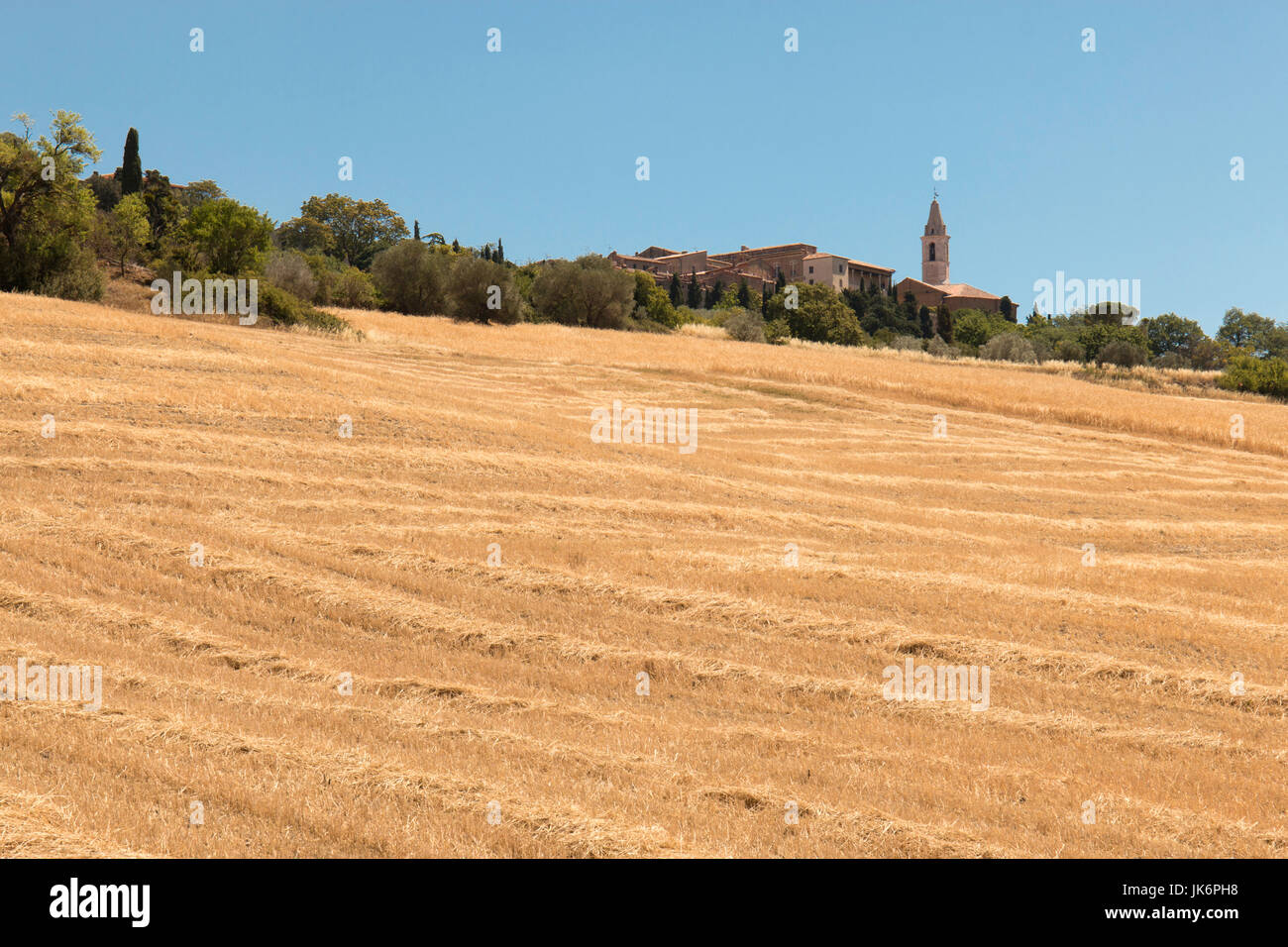 Ein Sommer Landschaft Szene über die Felder in Richtung der fernen Stadt Pienza auf einem Hügel der Val d'Orcia, Toskana, Italien Stockfoto