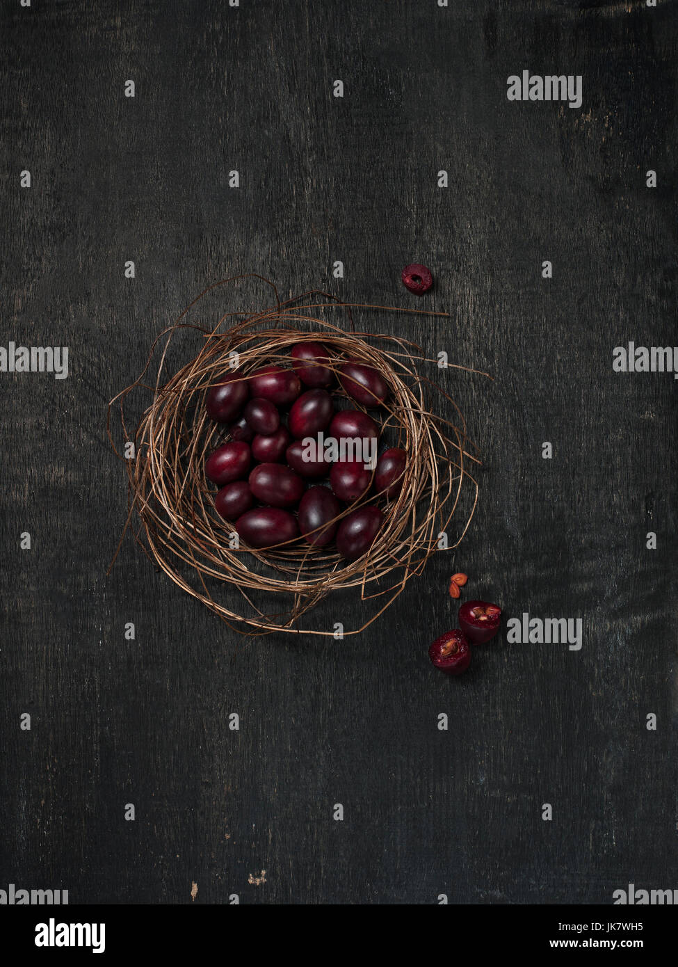 Carissa Carandas Bengal-Johannisbeere, Carandas-Pflaume, Kuranda mit Marmelade gesundes Obst auf hölzernen schwarzen Hintergrund Stockfoto