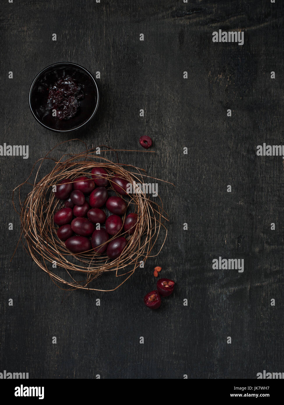 Carissa Carandas Bengal-Johannisbeere, Carandas-Pflaume, Kuranda mit Marmelade gesundes Obst auf hölzernen schwarzen Hintergrund Stockfoto