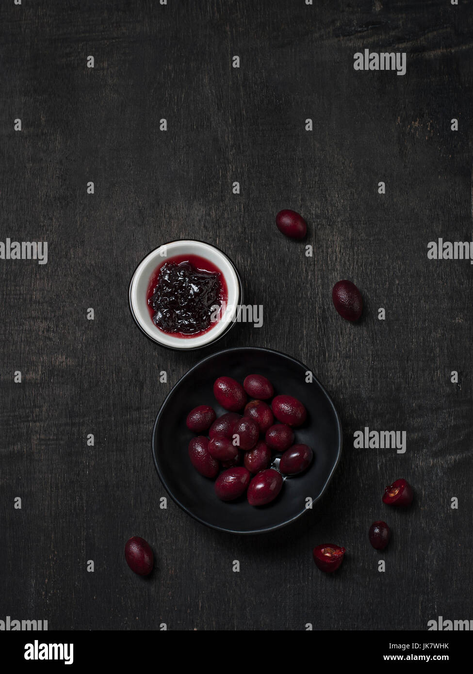 Carissa Carandas Bengal-Johannisbeere, Carandas-Pflaume, Kuranda mit Marmelade gesundes Obst auf hölzernen schwarzen Hintergrund Stockfoto