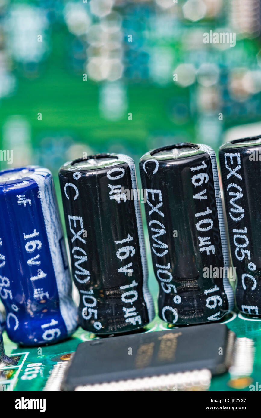 Detailgenauigkeit von elektrischen Kondensatoren auf einer grünen Leiterplatte (pcb). Stockfoto