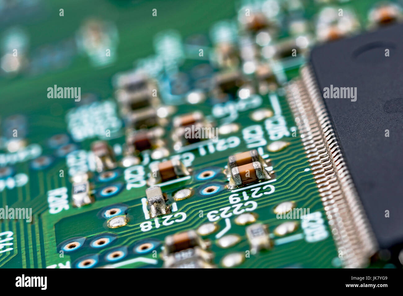 SMD-Komponenten (Surface Mount Technology) auf einer grünen Leiterplatte. Verdrahtung im Computer, Nahaufnahme des Stromkreises, Detail einer Leiterplatte. Stockfoto