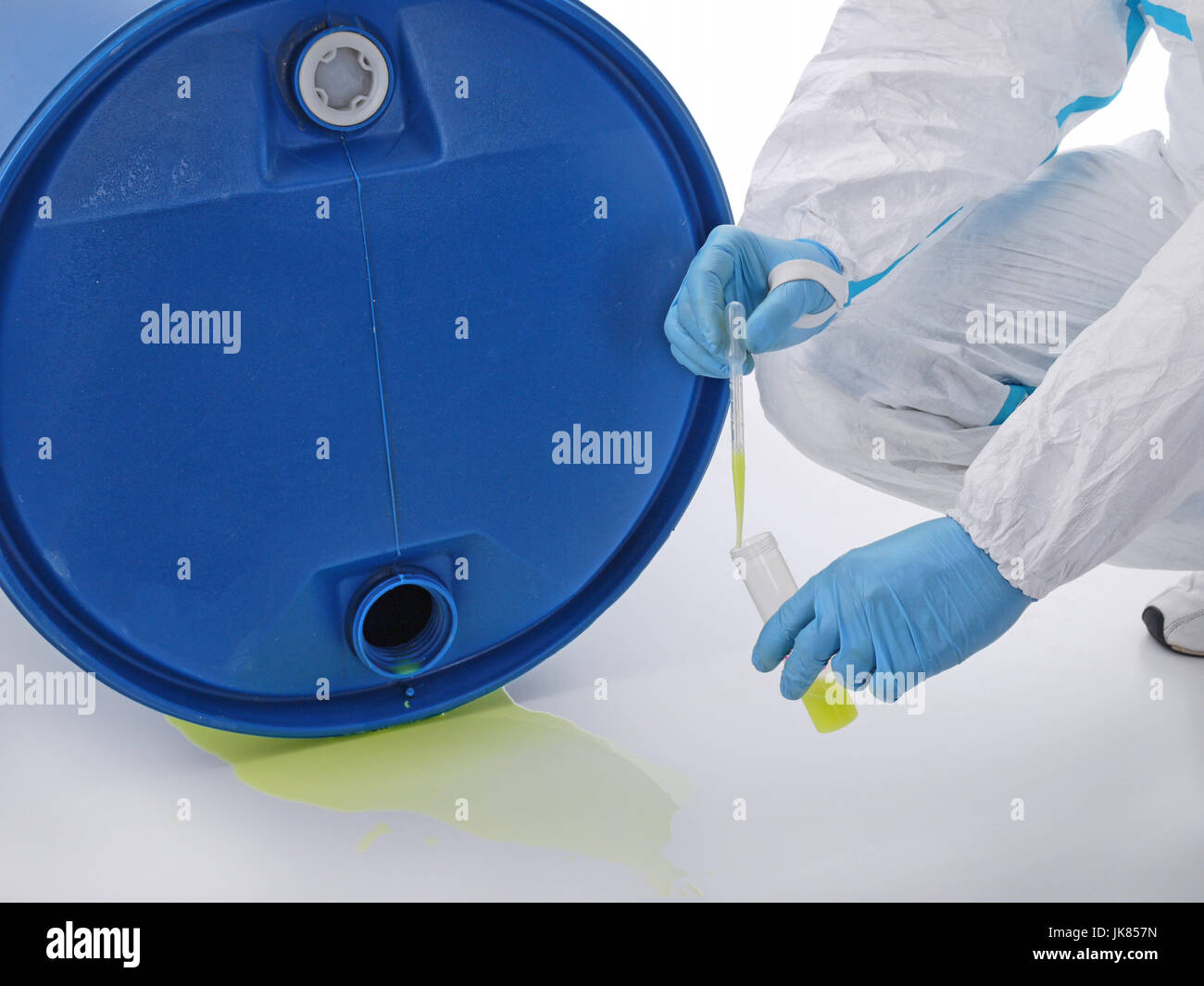 Nahaufnahme der Mann im Schutzanzug Probenahme gefährliche chemische Flüssigkeit austritt aus blauen container Stockfoto