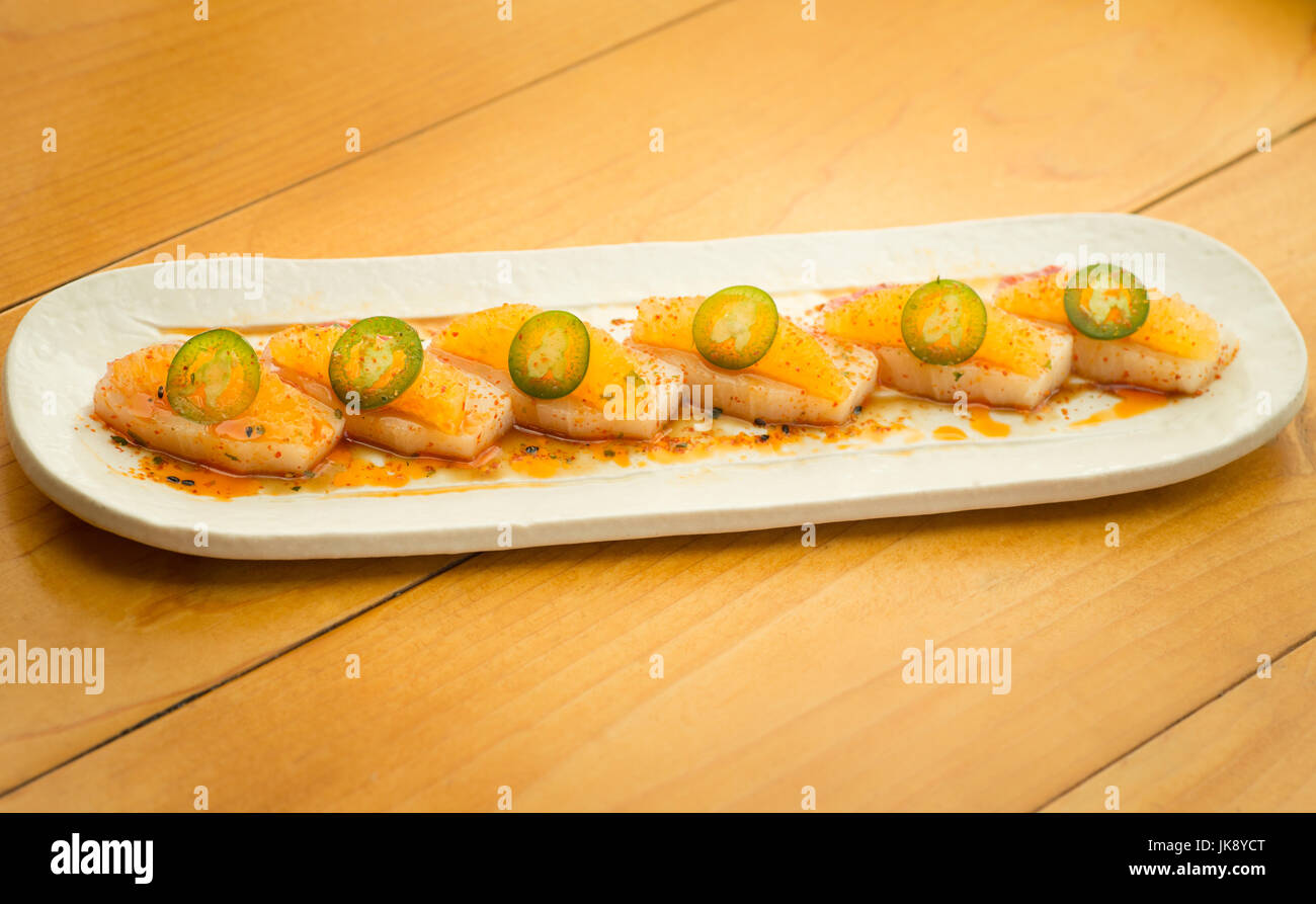 Nahaufnahme von Spezialität high-End Gelbflossen Thunfisch Sushi-Rolle mit Jalapeno auf Platte fertig zum Verzehr. Stockfoto