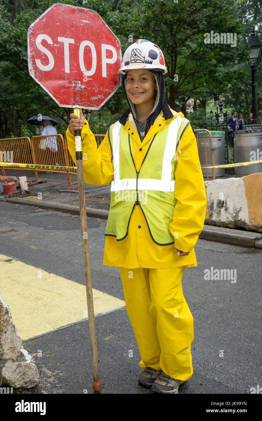 Eine hübsche junge Dame, die eine Flagger auf ein Bautrupp hält ein Stoppschild Newar Washington Square Park in Manhattan, New York City. Stockfoto