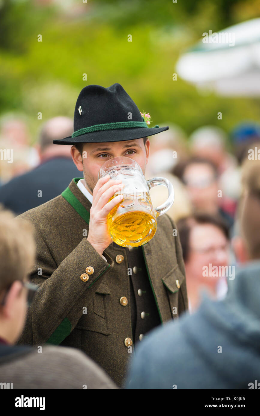 Junger deutscher Mann in traditioneller Tracht mit bayerischen Filz Hut und Kostüm trinken Bier aus einem stein Stockfoto