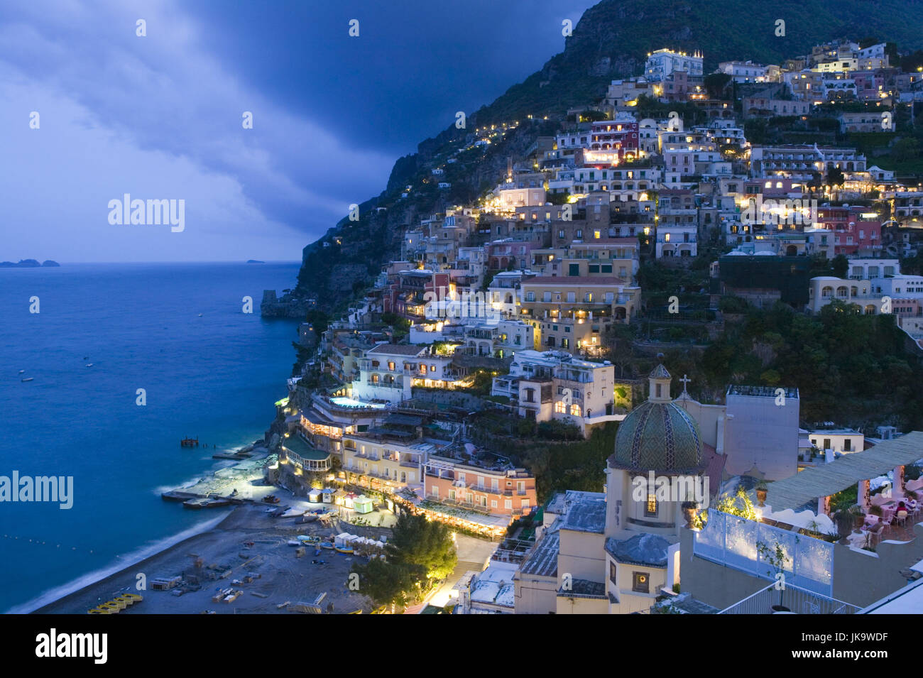 Italien, Kampanien, Amalfiküste, Positano, Stadtansicht, Abend, Lichter, Süditalien, Reiseziel, Stadt, Mediterran, Gotteshaus, Sakralbau, Architektur, findet, Mosaik, Kunstvoll, Kuppelbau, Berg, Hang, Glaube, Religion, Christentum, Kirche Santa Maria Assunta, Meer, Mittelmeer, Blaue Stunde, Beleuchtung, Stockfoto