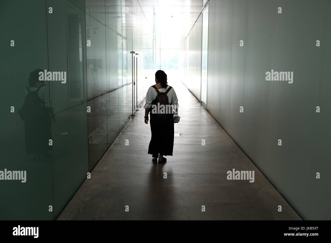 Mädchen geht hinunter Korridor in Richtung Licht Stockfoto