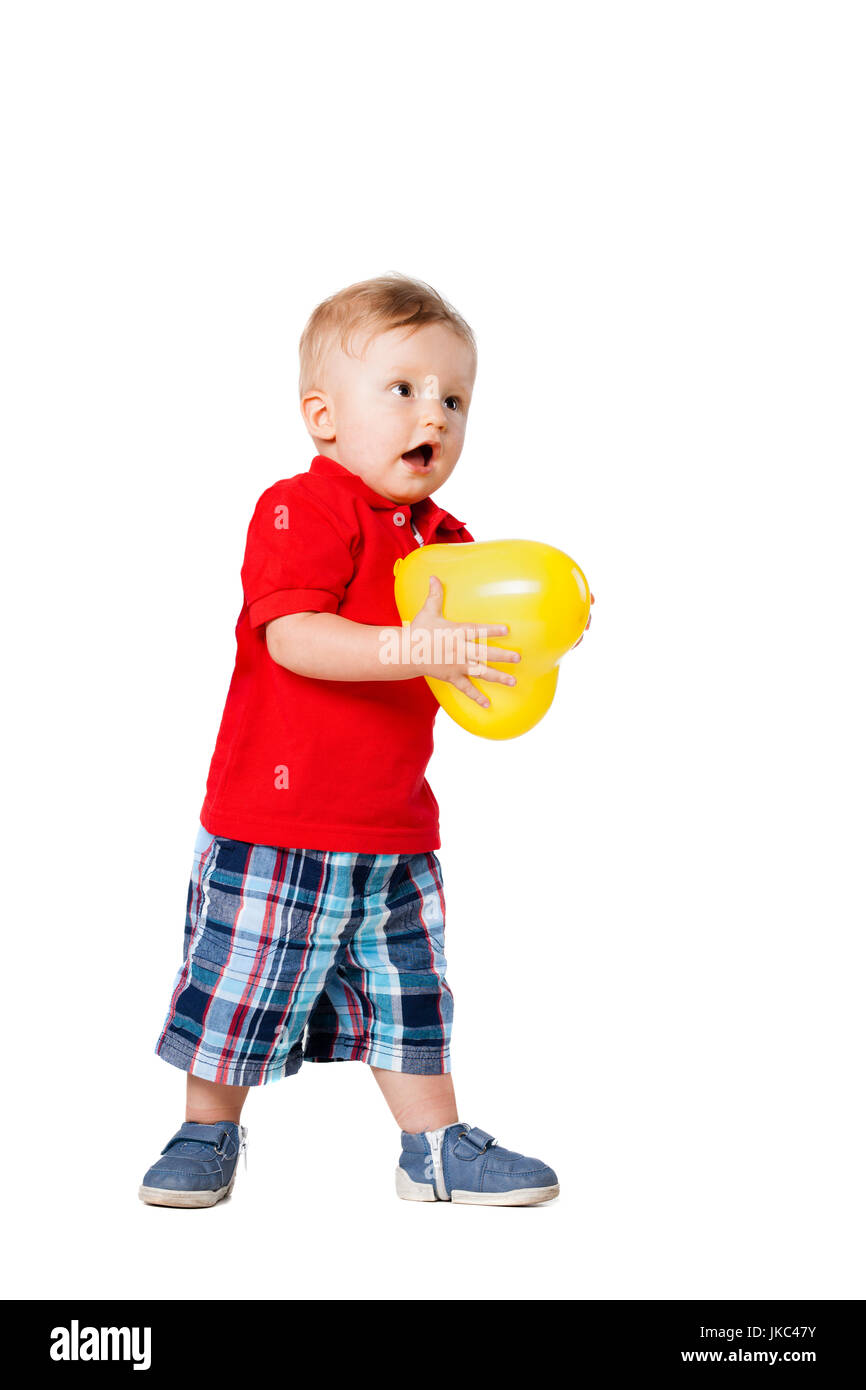 Baby Junge stand auf dem Boden mit einem gelben Ballon Stockfoto
