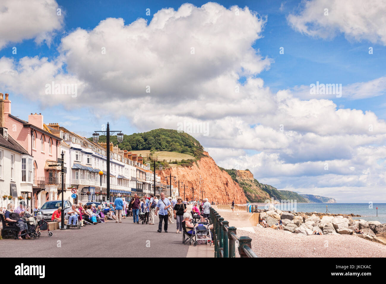 3. Juli 2017: Sidmouth, Dorset, England, UK - Besucher flanieren auf der Promenade an einem sonnigen Sommertag mit blauen Himmel und riesige Cumulus-Wolken. Stockfoto