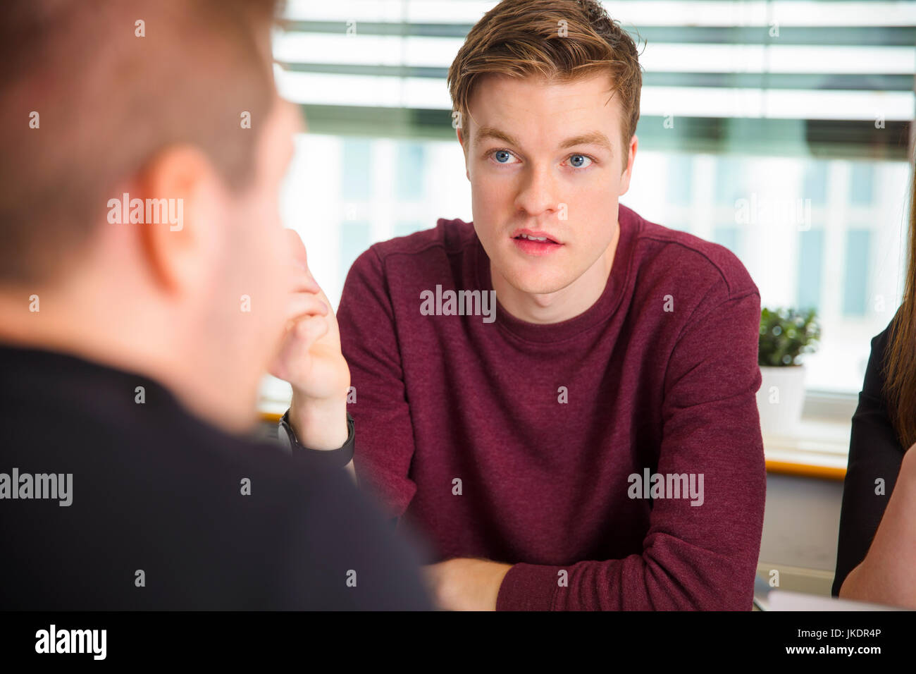 Geschäftsmann, Blick auf Kollegen während der Kommunikation im Büro Stockfoto