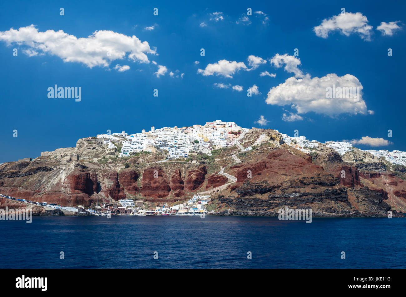 Dorf Oia, Santorini Cycladen Inseln, Griechenland. Schöne Aussicht auf die Stadt mit weißen Häusern, blauen Kirche Dächern und vielen bunten Blumen. Stockfoto