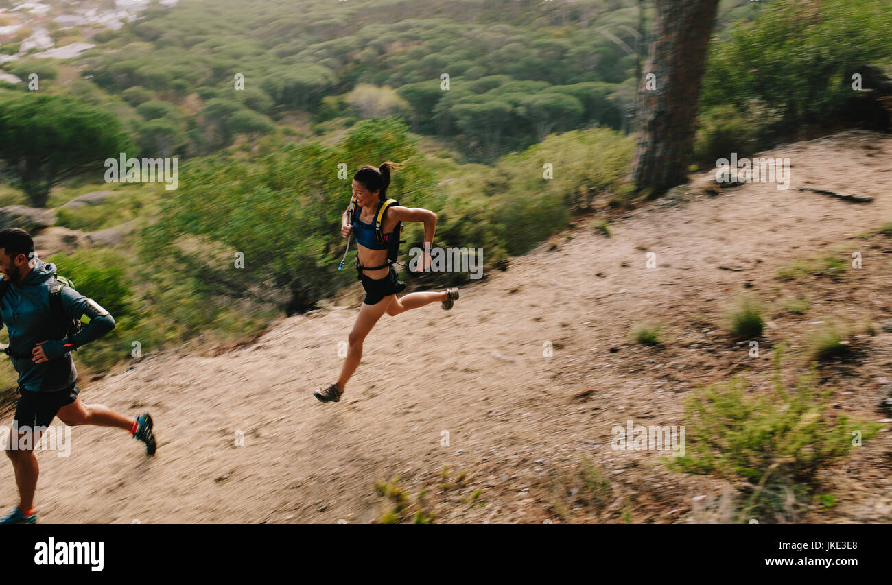 Zwei Läufer auf Bergweg. Junger Mann und Frau laufen in der Natur. Trail-running-Training. Stockfoto