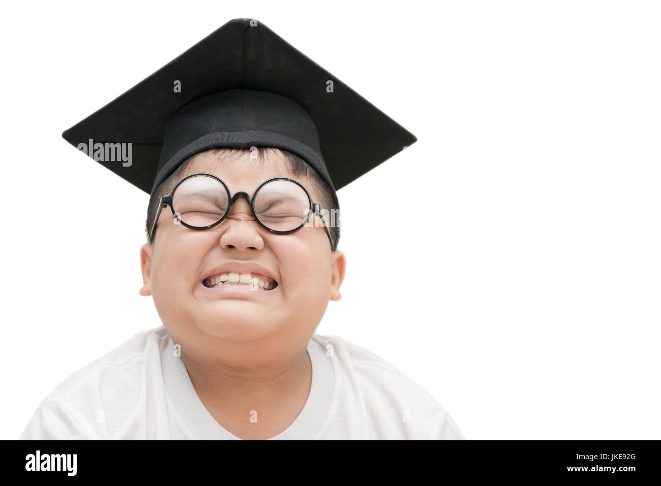 asiatische Schulabsolvent Kind gelangweilt mit Graduation Cap isoliert auf weißem Hintergrund Stockfoto
