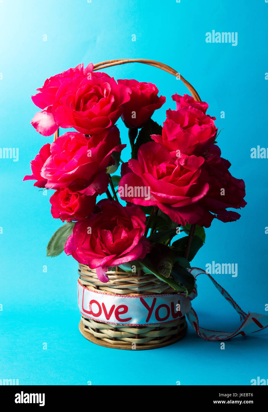 Rote Rosen Korb türkis blauem Hintergrund Stockfoto