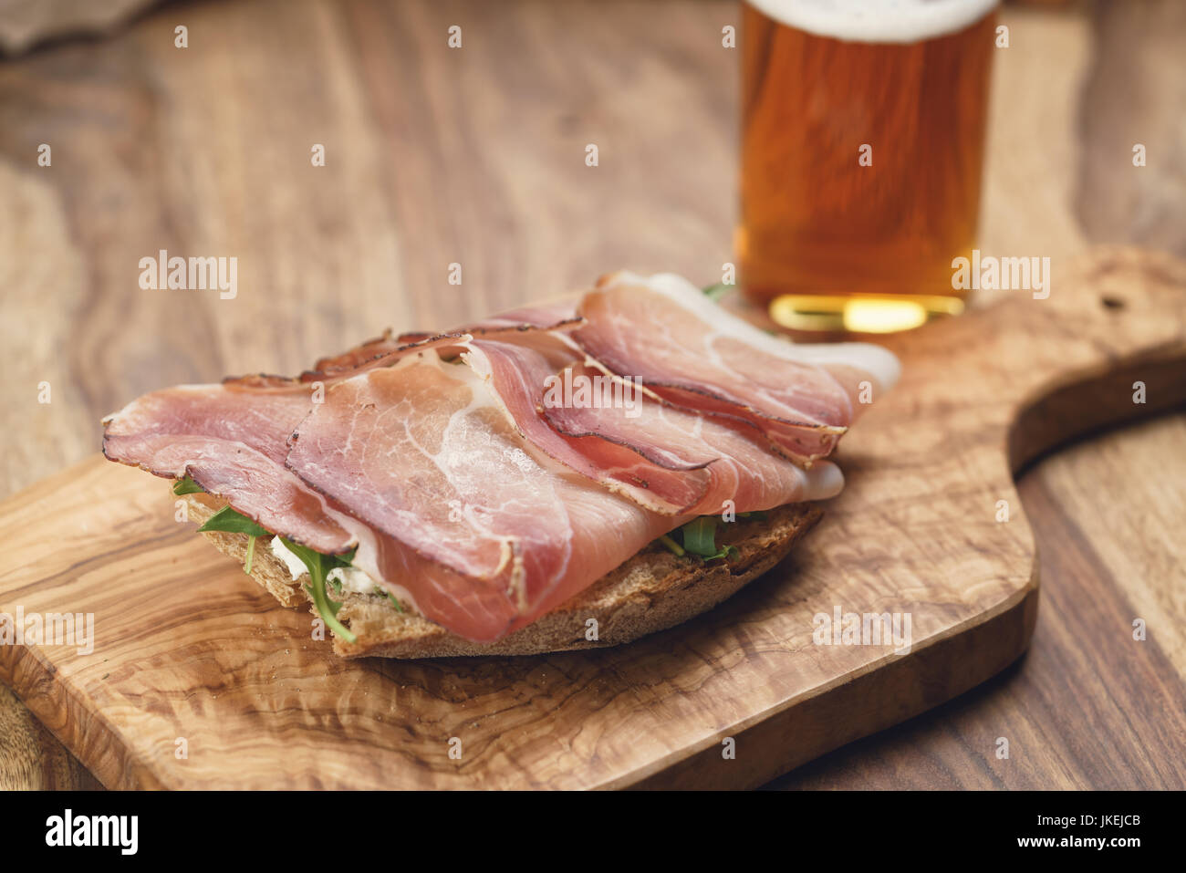 Italienisch-Sandwich mit Speck, Rucolasalat und Bier Stockfoto