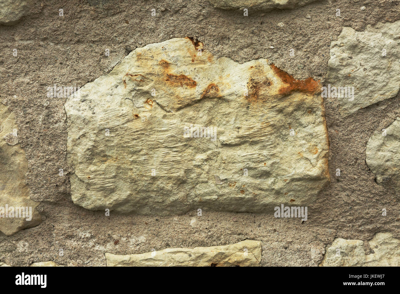 Nahaufnahme von einem großen Stein in einer alten historischen Mauer mit sichtbaren Details und Porosität und hellen Mörtel um. Horizontale Hintergrund, Textur Stockfoto