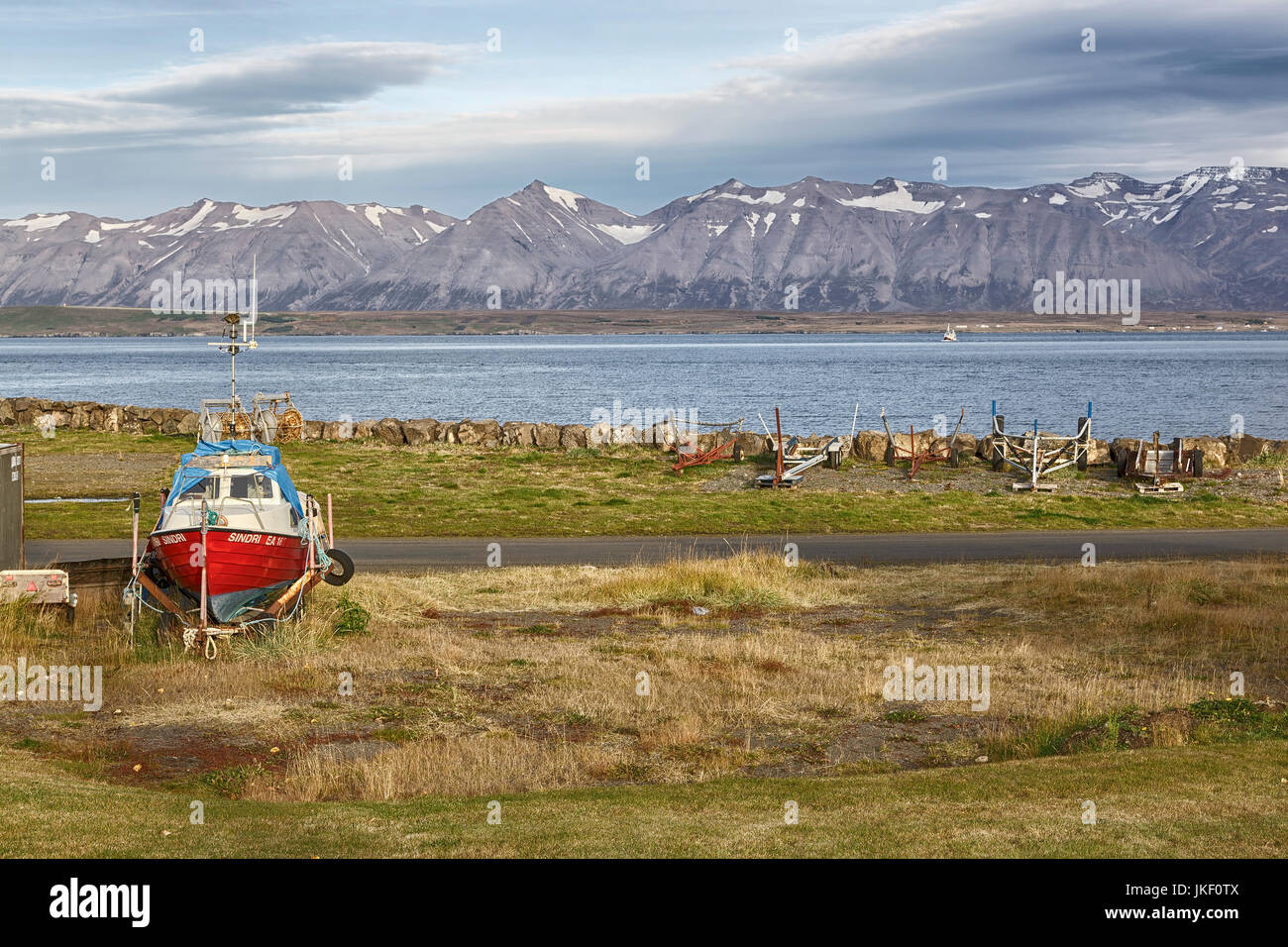 Eine kleine Bootswerft in Dalvik auf einer der nördlichen Halbinseln Islands, mit einer spektakulären Bergkette in der Ferne Stockfoto