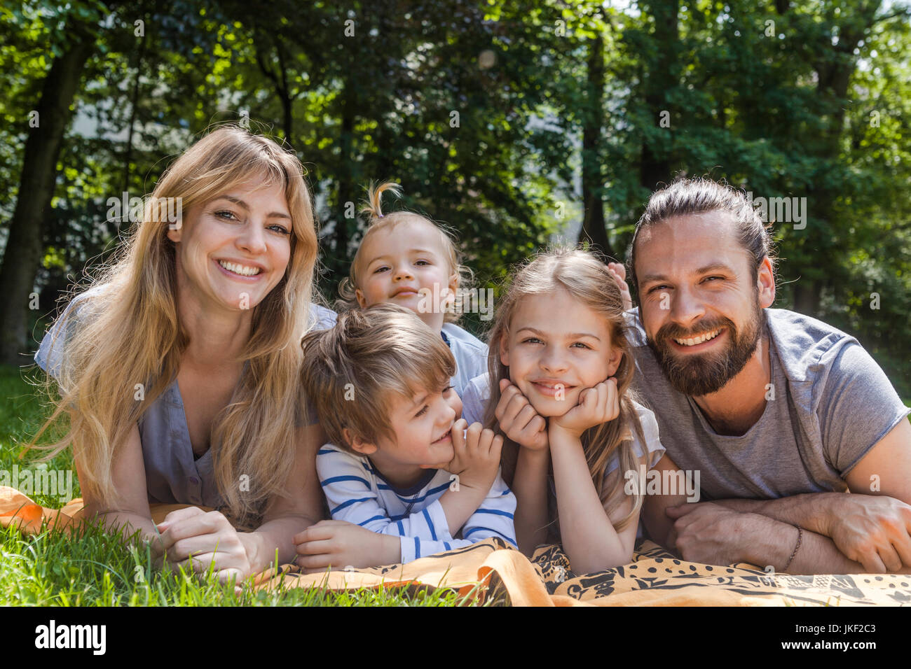 Portrait von Happy Family liegend auf der Wiese Stockfoto