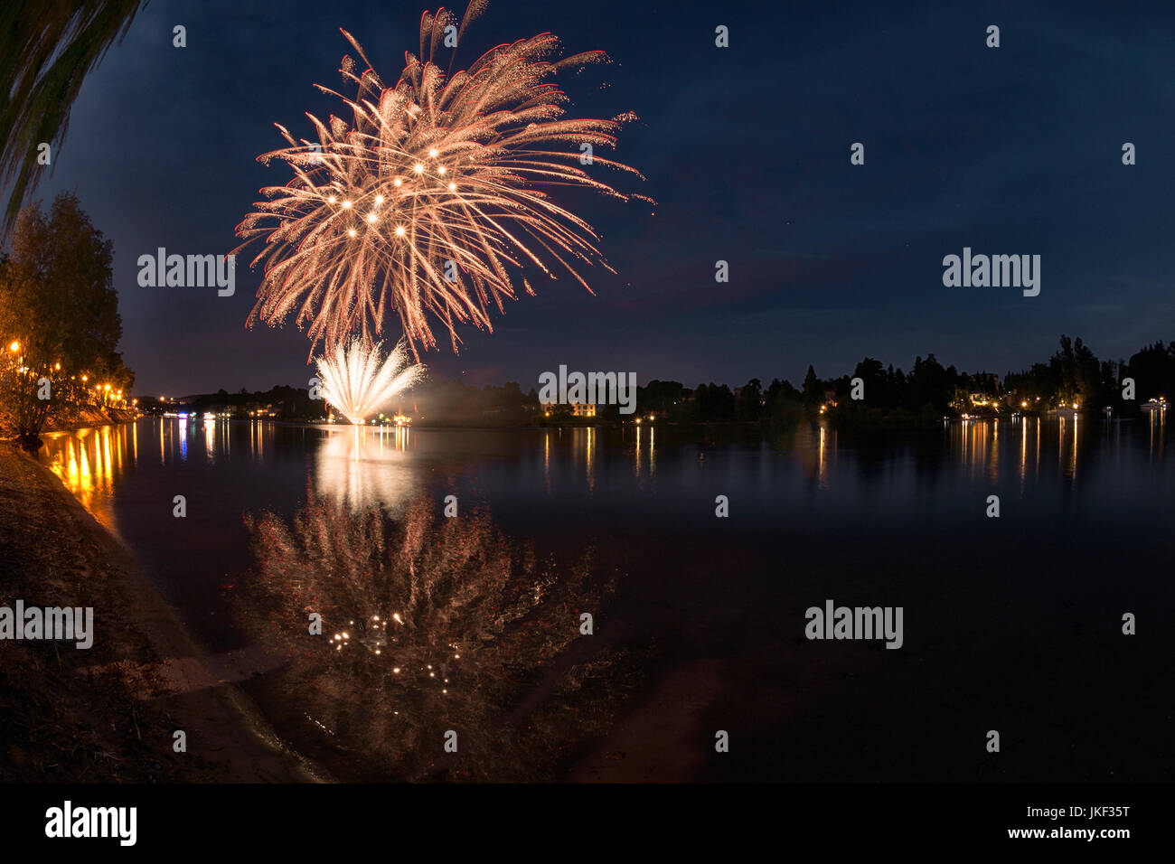 Feuerwerk auf dem Fluss Ticino an einem Sommerabend mit Landschaft im Hintergrund Stockfoto