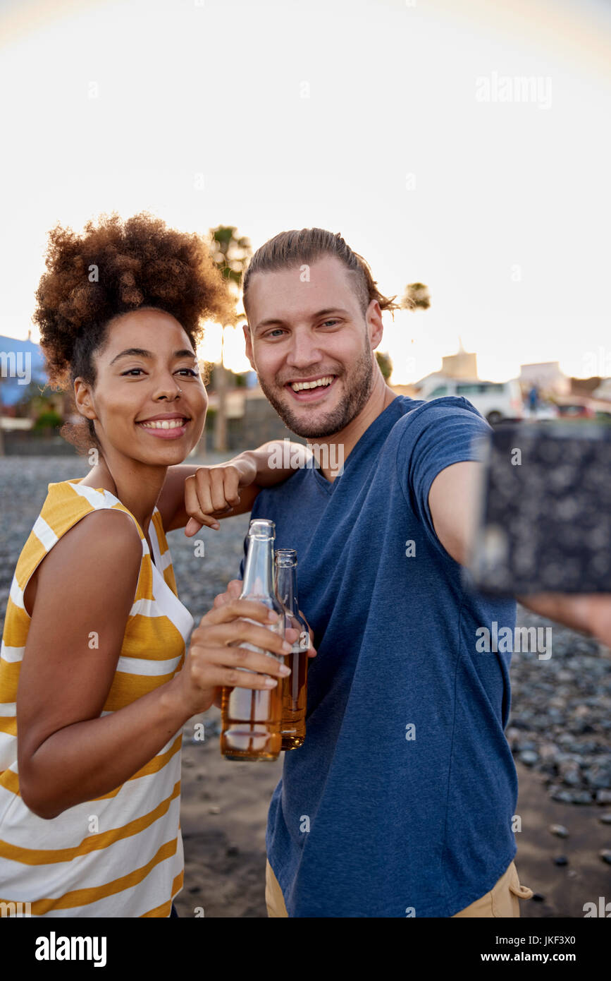 Zwei Freunde mit Bierflaschen unter selfie am Strand Stockfoto