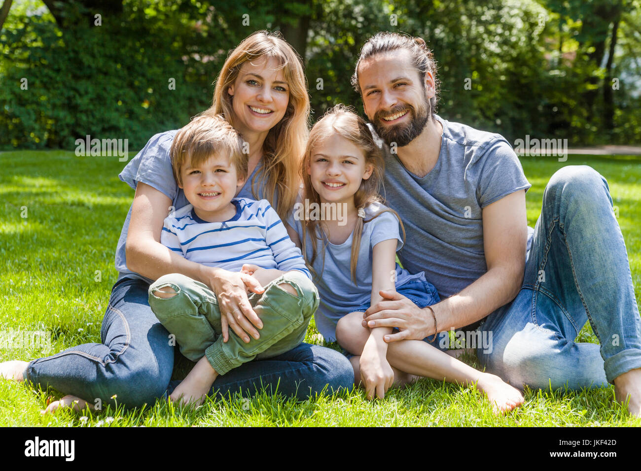 Portrait der glücklichen Familie sitzt auf der Wiese Stockfoto