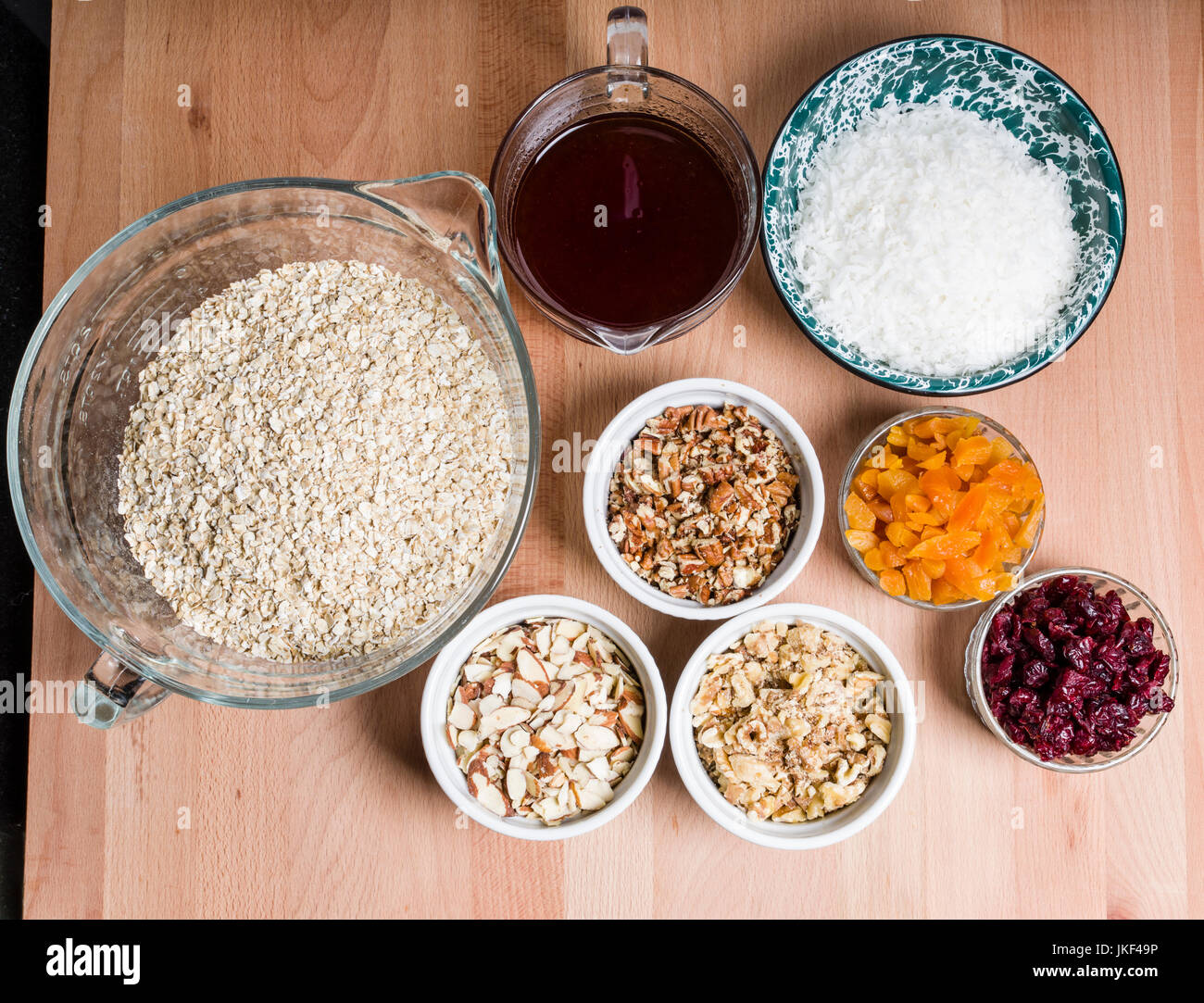 Schalen mit Zutaten für die Herstellung von frischen Müsli mit getrockneten Früchten Stockfoto