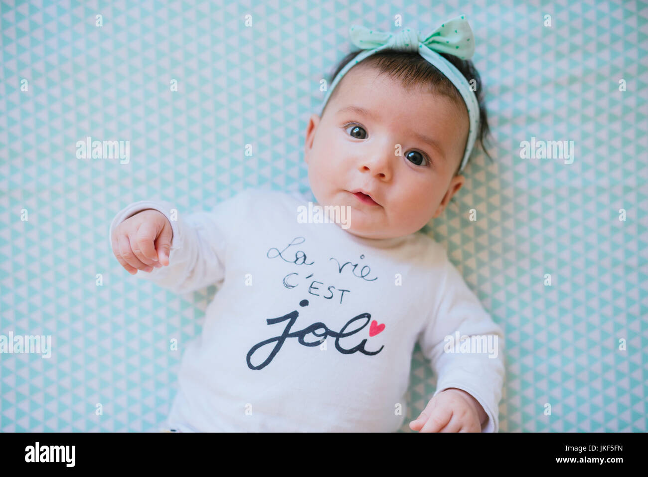 Baby Mädchen mit einem Haarband liegend auf Bett Stockfoto
