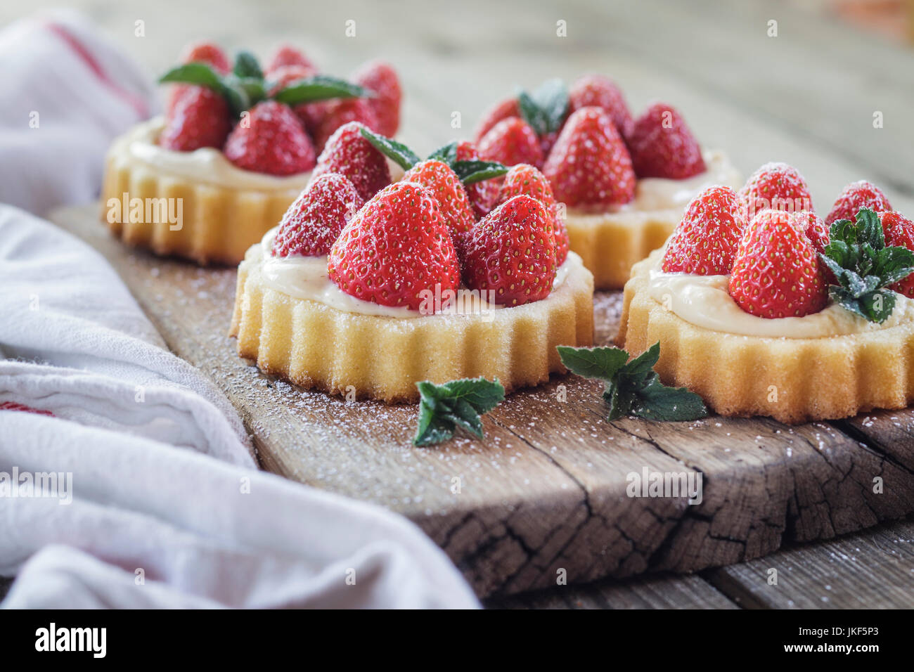 Törtchen mit Pudding auffüllen und Erdbeeren Stockfoto