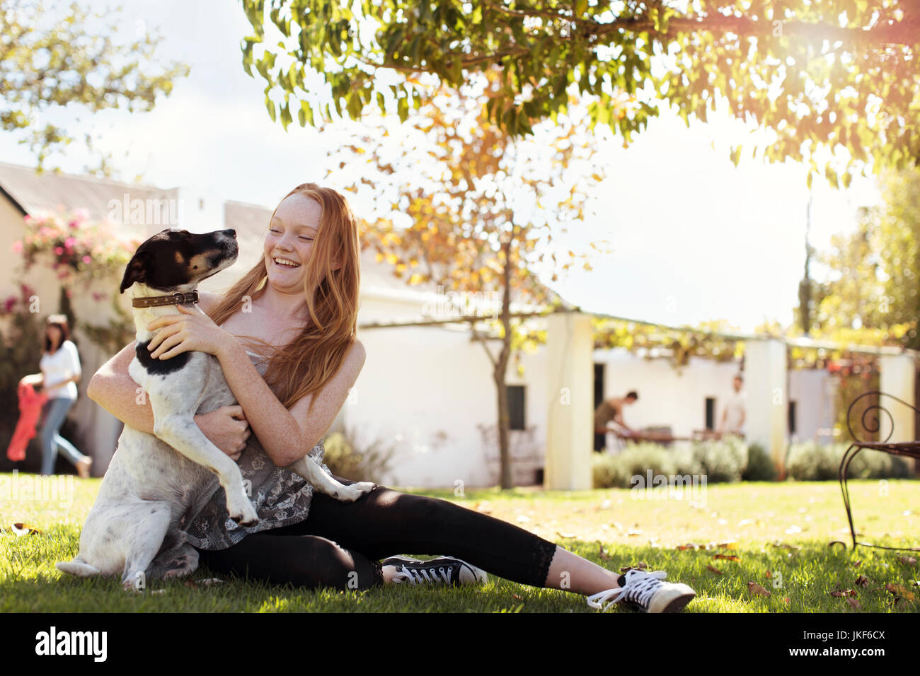 Glückliches Mädchen spielen mit Hund im Garten Stockfoto