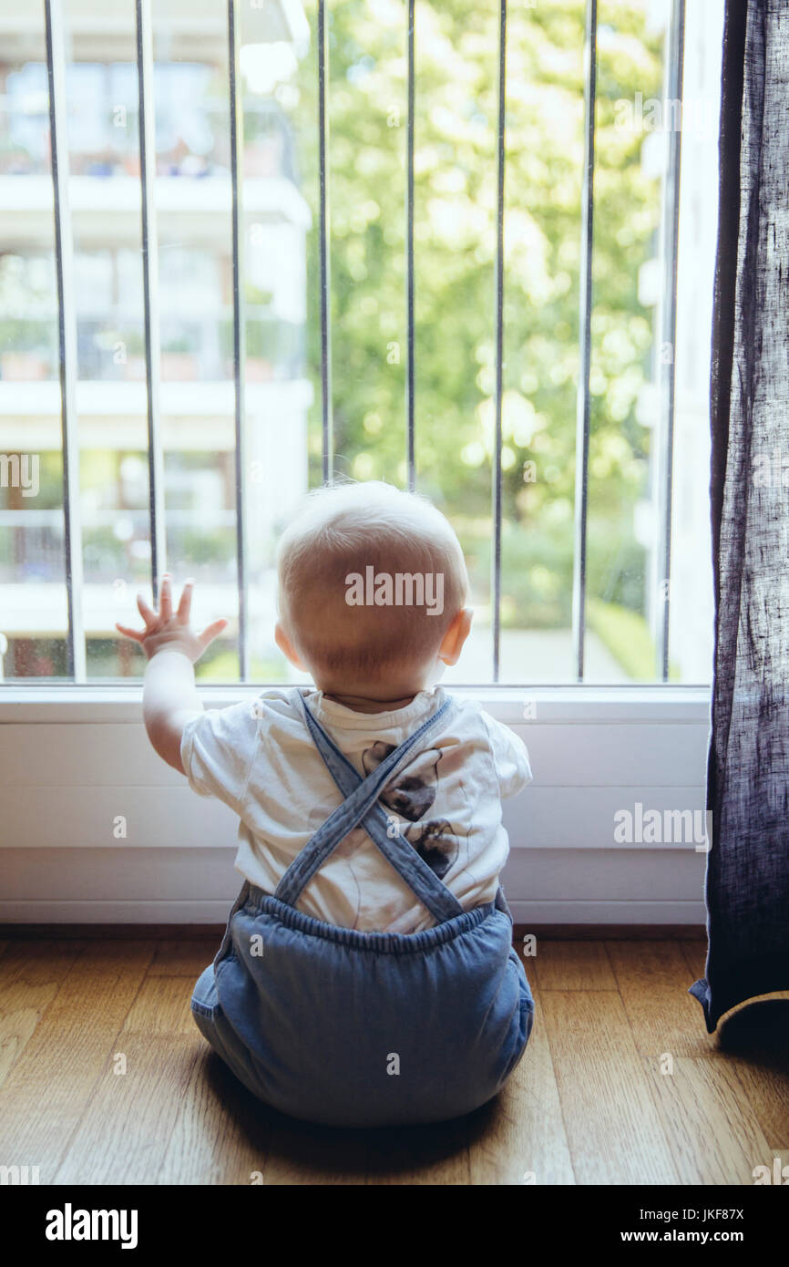 Rückansicht des baby boy Blick durch Fenster Stockfoto