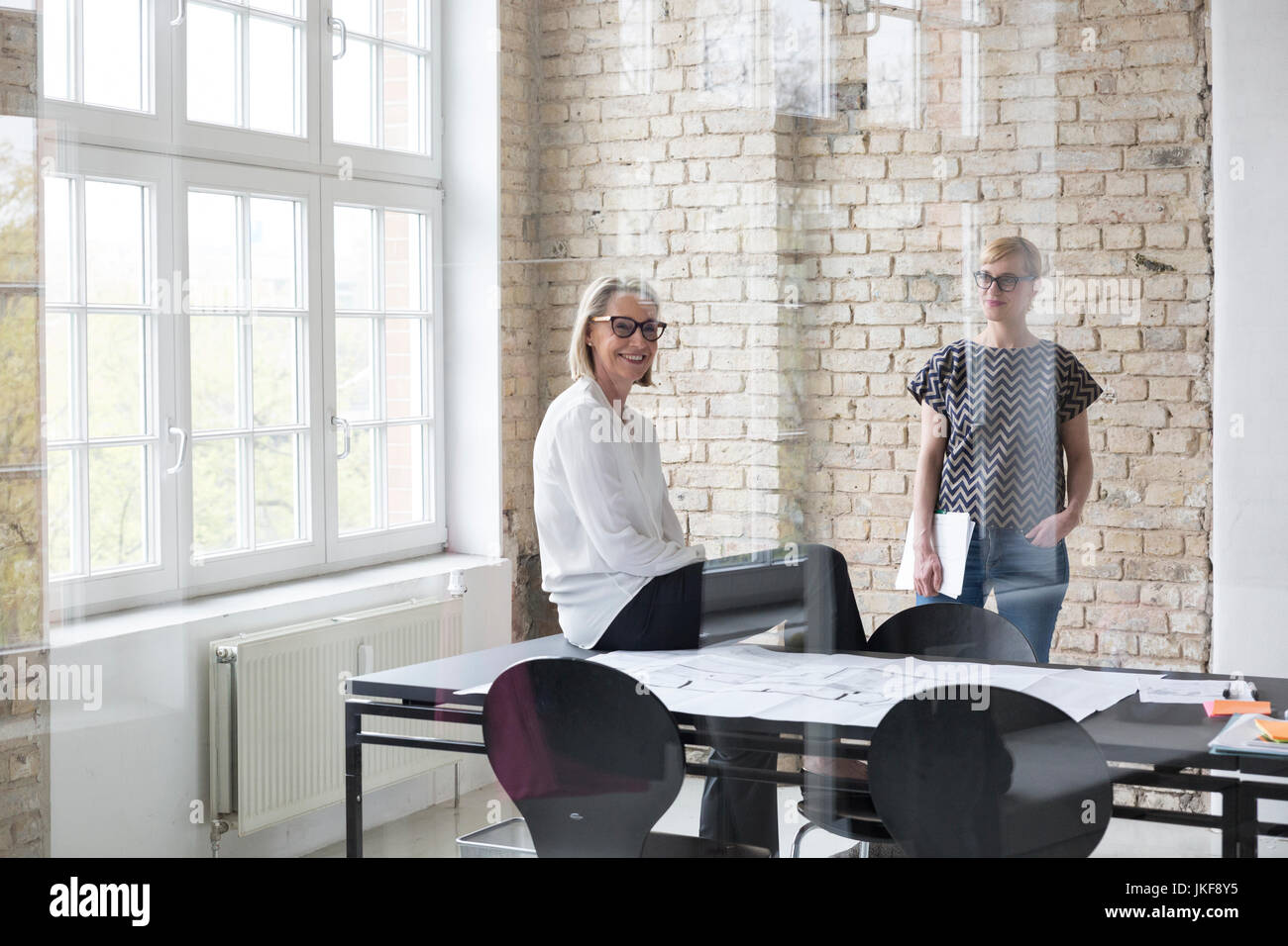 Reife Geschäftsfrau arbeiten mit jüngeren Kollegen im Büro Stockfoto