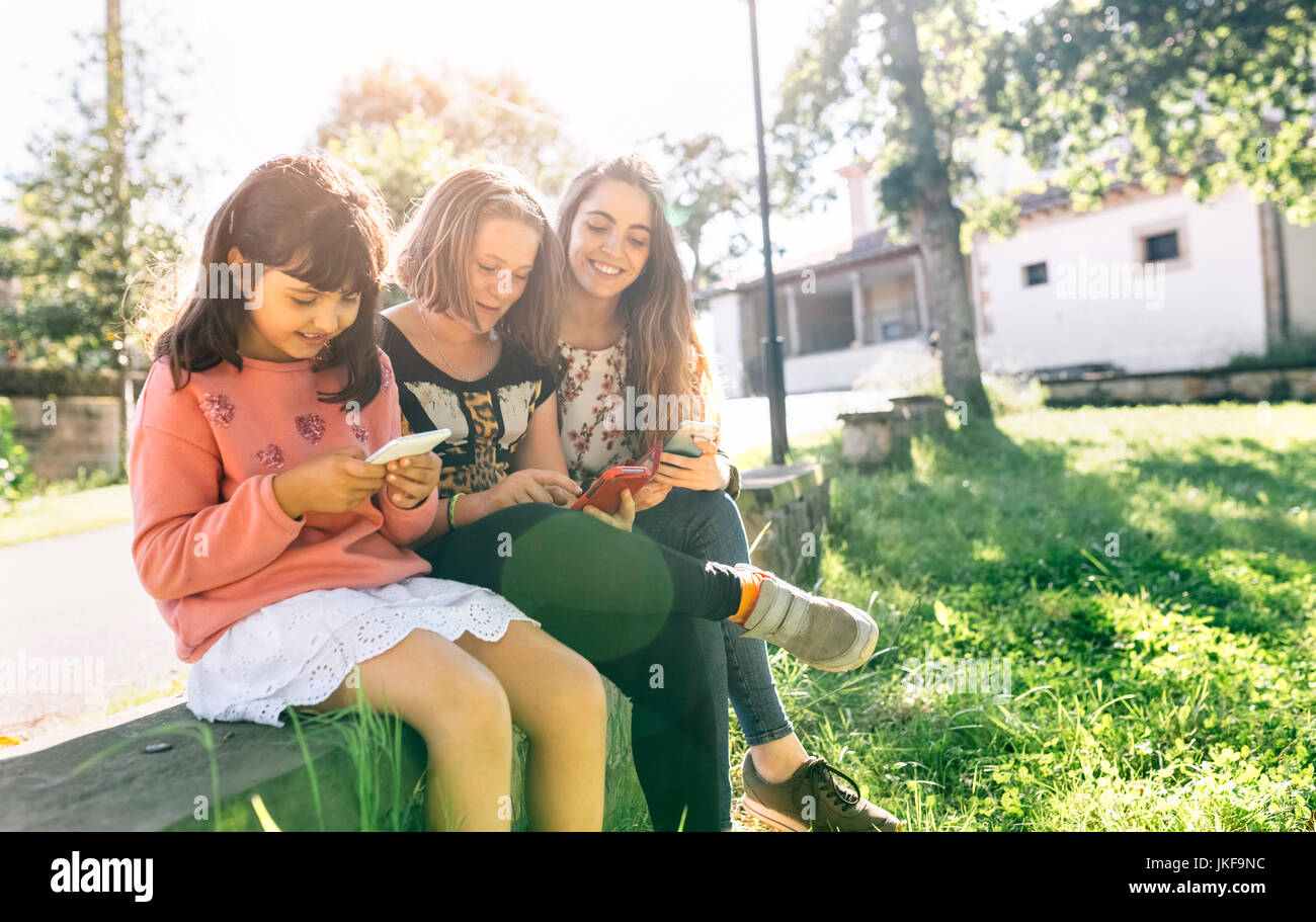 Drei Mädchen mit ihren Smartphones im Freien Stockfoto