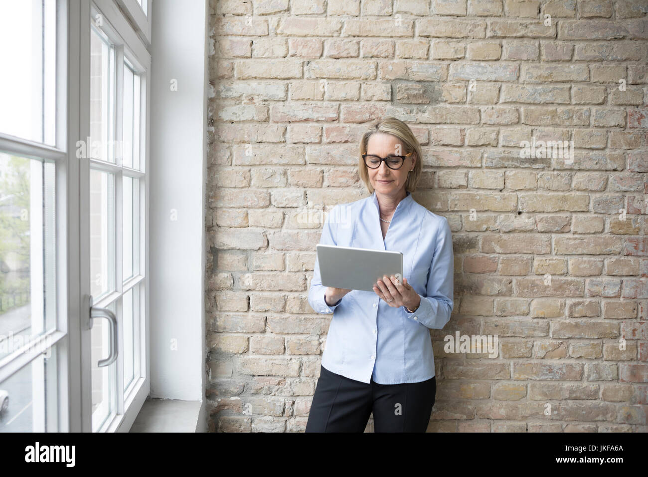 Reife Geschäftsfrau mit digitalen Tablet Stockfoto