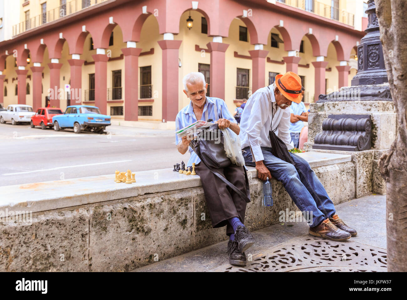 Zwei ältere kubanische Männer, lesen und warten auf eine Partie Schach auf Paseo Prado, Alt-Havanna, Kuba Stockfoto