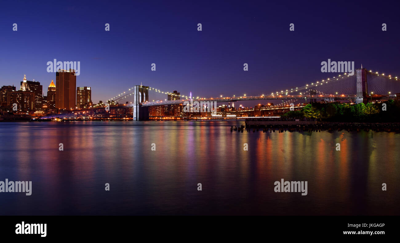 Manhattan und die Brooklyn bridge ein Sommerabend in der blauen Stunde mit Sternen und farbige Reflexe auf die Lichter der Stadt. Stockfoto