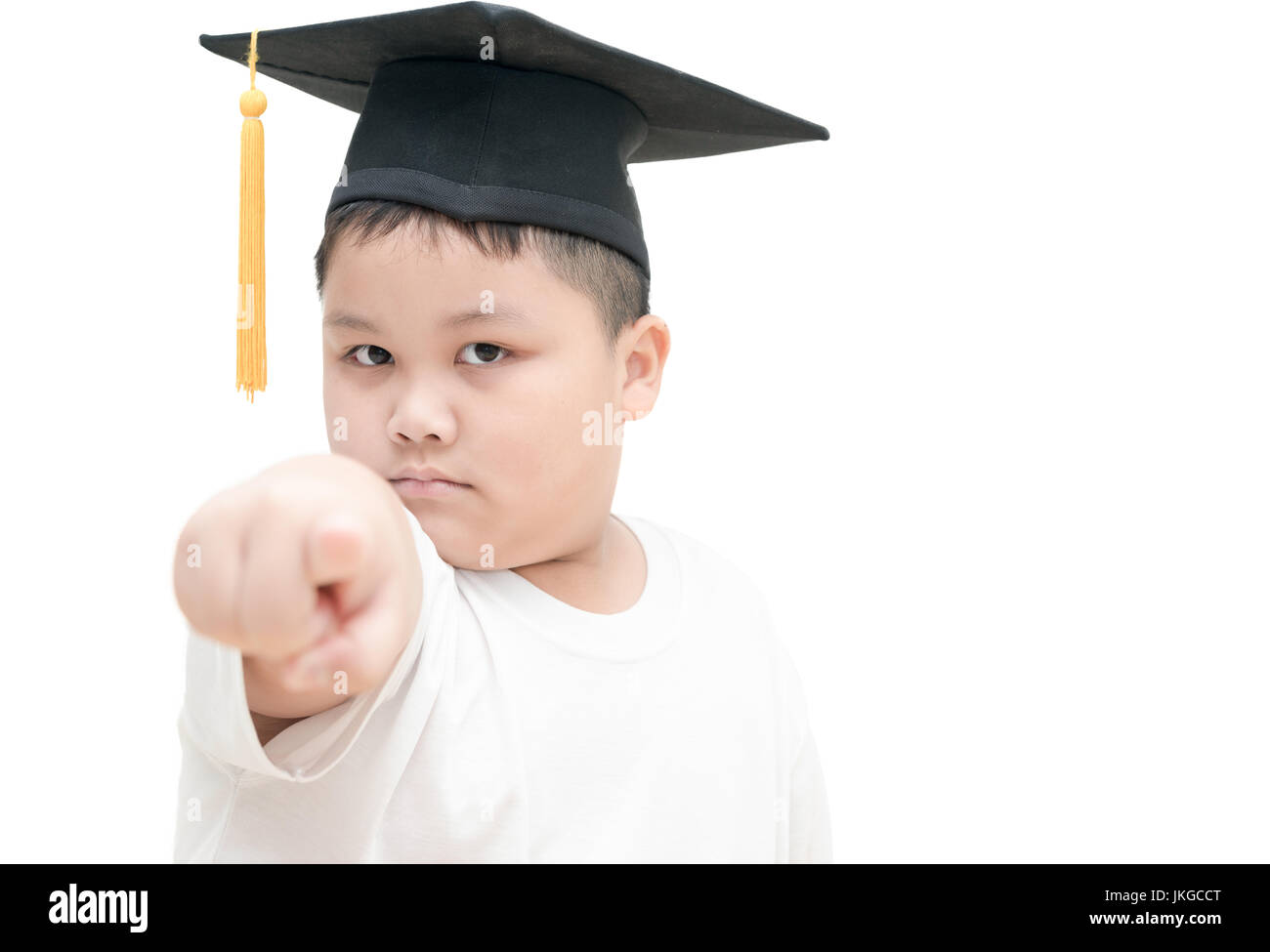 asiatische Schulabsolvent Kind mit Graduation Cap wies die Finger-Befehl isoliert auf weißem Hintergrund Stockfoto