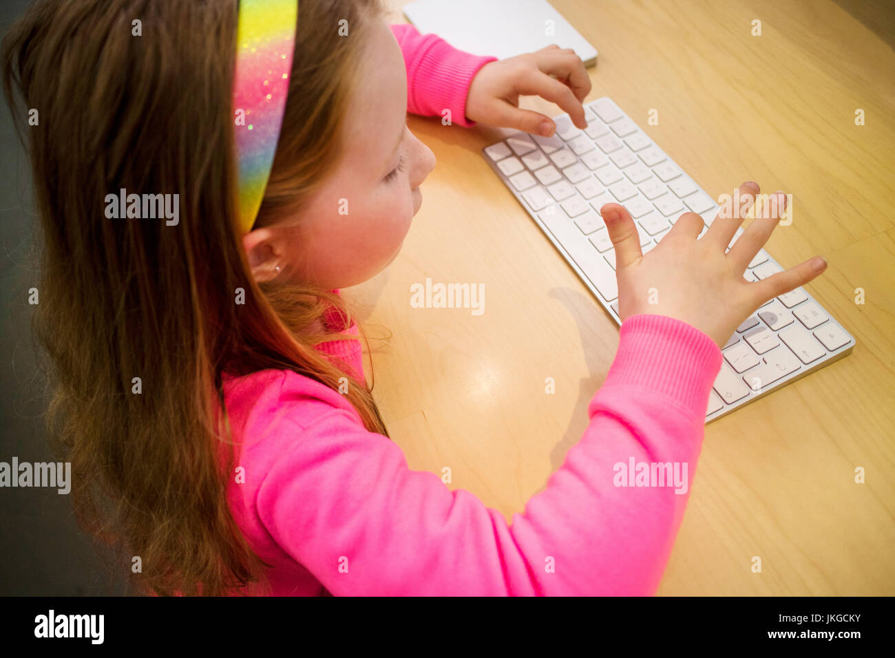 7 Jahr der Mädchen schreiben auf Apple Tastatur im Apple Store Stockfoto