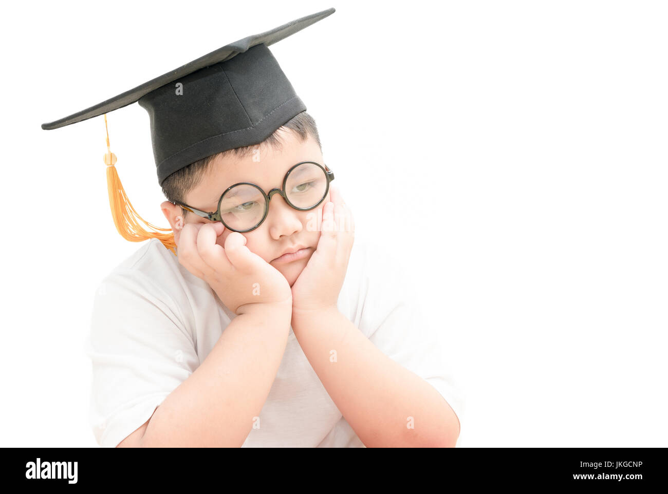 asiatische Schulabsolvent Kind gelangweilt mit Graduation Cap isoliert auf weißem Hintergrund Stockfoto
