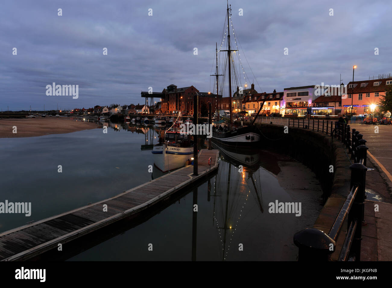 Dämmerung, Boote neben der Anlegestelle in der Uferstraße, Wells-Next-the-Sea, Norfolk Nordküste; England-UK Stockfoto