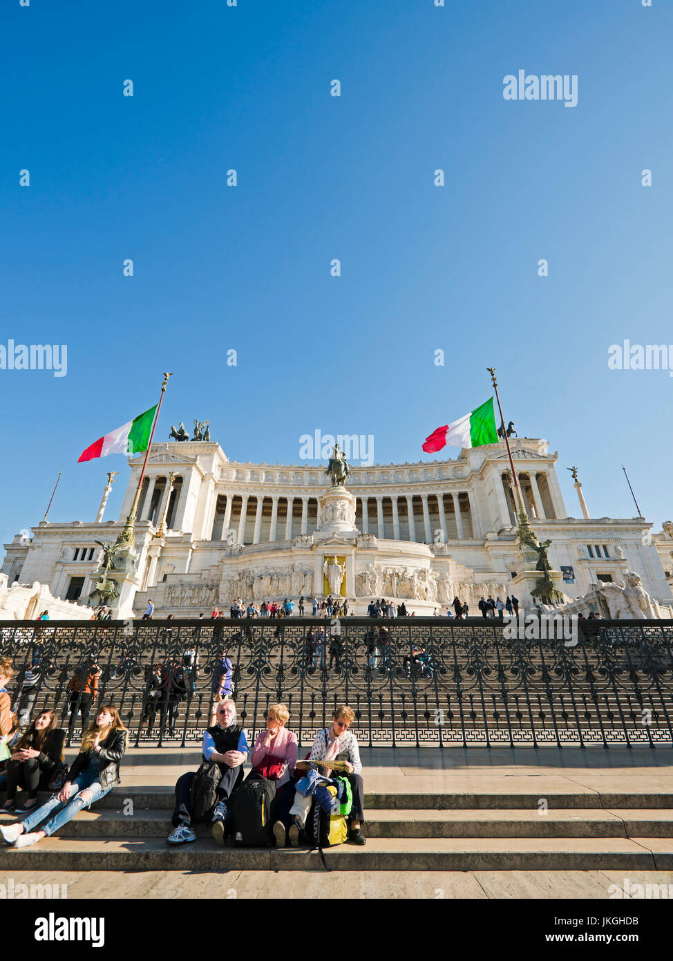 Vertikale Perspektive von Menschen sitzen auf den Stufen vor dem Vittoriano oder Victor Emanuele II Denkmal in Rom. Stockfoto