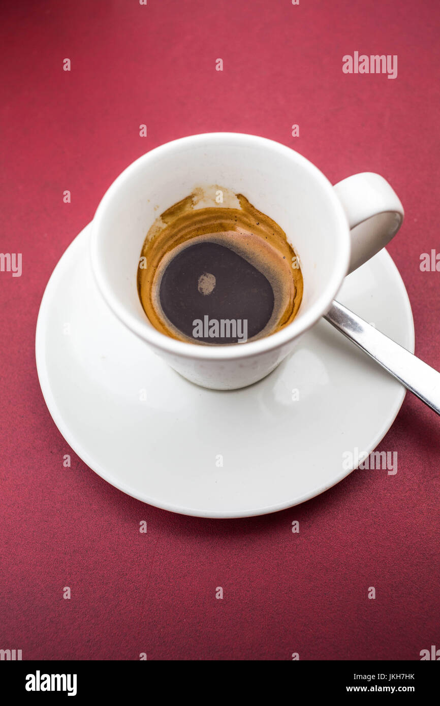 Halb betrunken Tasse Esspresso Kaffee auf einem roten Tisch Stockfoto