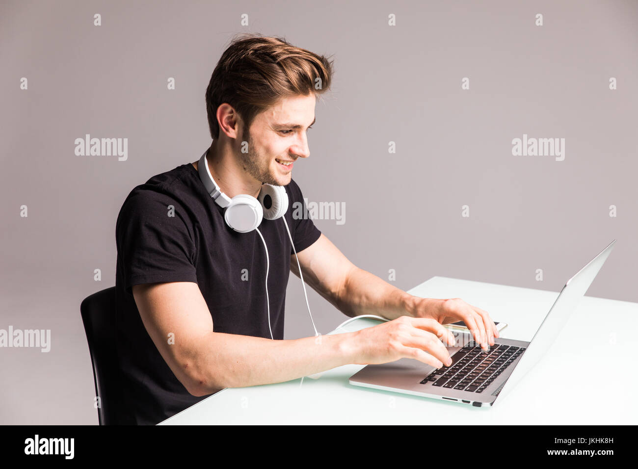Bild eines jungen Mannes am Computertisch auf laptop Stockfoto
