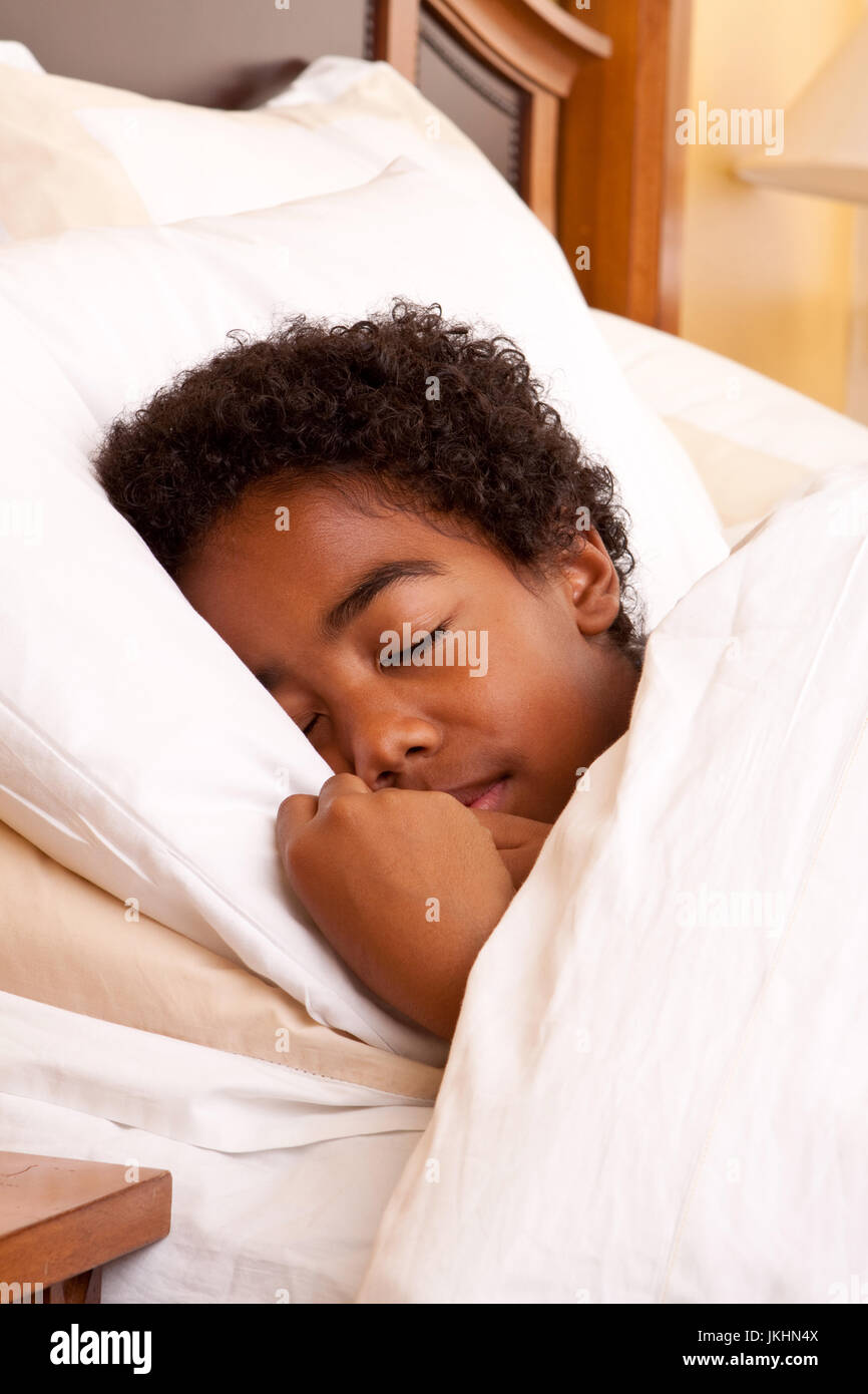 Afrikanische amerikanische Jungen in seinem Bett schlafen. Stockfoto