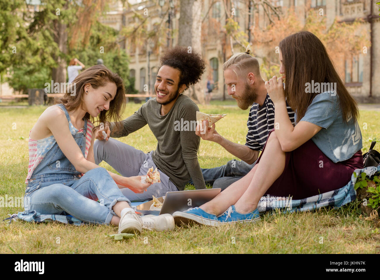 Studenten, die Picinic auf dem Rasen vor der Universität. Stockfoto